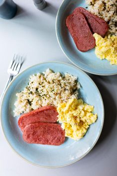 two blue plates with food on them next to utensils