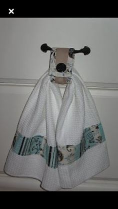 a white towel hanging from a hook on a door with an animal print and blue trim