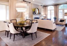 a dining room table surrounded by white chairs