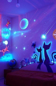 a bedroom decorated in purple and blue with cats on the wall, stars and planets