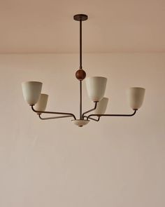 a chandelier with five lights hanging from it's sides in a room