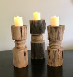 three wooden candle holders sitting on top of a table