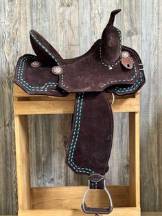 a brown saddle with blue stitching on it