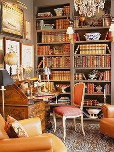 a living room filled with lots of furniture and bookshelves full of books on top of them