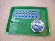 a green tray with bowls and spoons on it