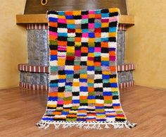 a multicolored rug sitting on top of a wooden floor