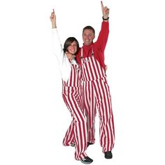 a man and woman dressed in red and white striped pajamas posing for the camera with their hands up