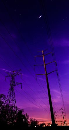 power lines and telephone poles against a purple sky