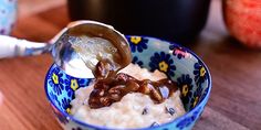 a bowl filled with oatmeal topped with nuts and caramel sauce next to an apple