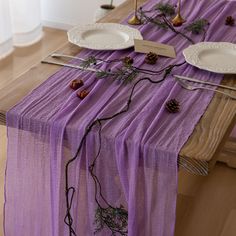 the table is set with pine cones and place settings for two people to sit at