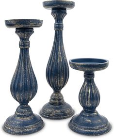 three blue candlesticks are sitting next to each other