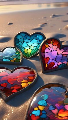 several heart shaped stained glass pieces on the sand