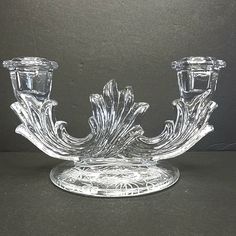 a clear glass candle holder with two candles