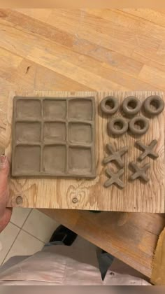 a person is holding a tray with dough and rolling wheels on it, next to other molds