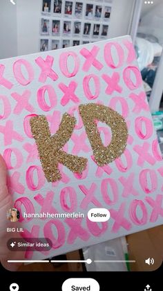 someone is holding up a pink and gold card with the letter k on it,