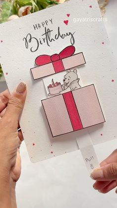 someone holding up a card with a bear in a gift box on it that says happy birthday