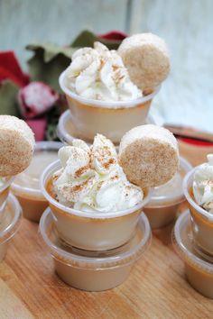 there are several desserts in small cups on the table with whipped cream and cinnamon sprinkles