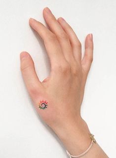 a person's hand with a small tattoo on the middle of their left wrist