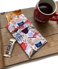 a cup of coffee and some candy on a wooden tray