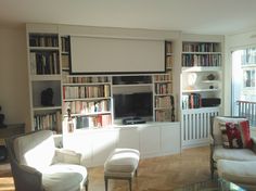 a living room filled with furniture and bookshelves