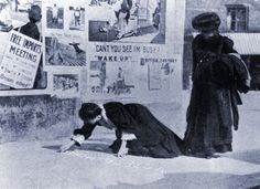 an old black and white photo of two women in front of a wall with posters on it