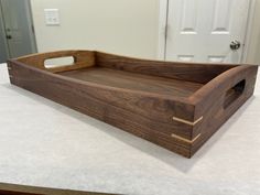 a wooden tray sitting on top of a counter next to a white door with a handle