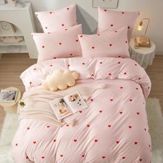 a pink bed with red hearts on it