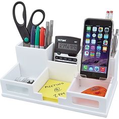 a cell phone and pen holder with pens, scissors, and other items in it