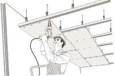 a man is working on the ceiling with an electric drill and screwdriver in his hand