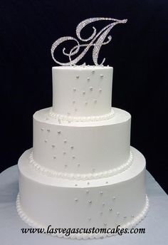 a three tiered wedding cake with white frosting