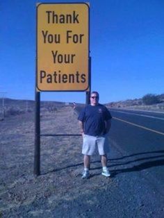 a man standing next to a yellow sign that says thank you for your patients