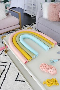 a table with yarn, scissors and other crafting supplies on it in a living room