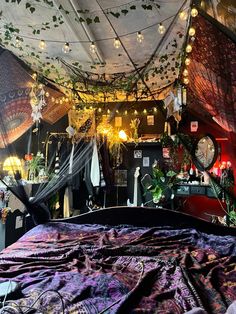 a bed covered in lots of plants and hanging lights