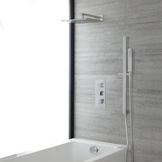 a white bath tub sitting next to a wall mounted shower faucet