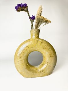 there is a yellow vase with flowers in it