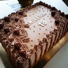 a heart shaped cake with chocolate frosting and cherries on the top that says happy birthday