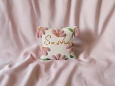 a pink and white pillow with the word sapha written in cursive writing on it