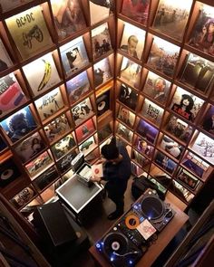 an overhead view of a dj mixing in a room with many pictures on the walls