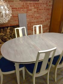 a dining room table with six chairs and a fire place in the backround