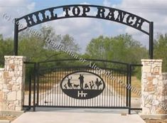 the entrance gate to hill top ranch with an iron sign above it that says hill top ranch