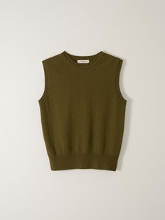 the cropped sweater vest in olive green is shown on a white surface, and it has