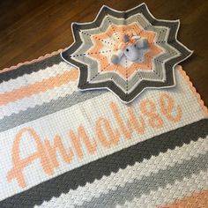 a crocheted blanket with an orange and gray star on it that says amamalia