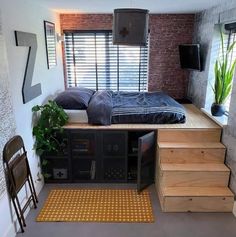 a bed sitting on top of a wooden floor next to a tv mounted above it