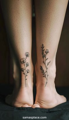 two women's legs with tattoos on them, one has flowers and the other has leaves