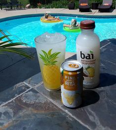 some drinks are sitting next to a pool