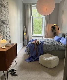 a bed room with a neatly made bed next to a window