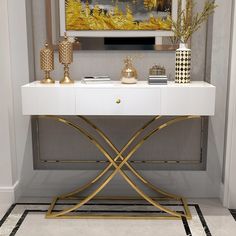 a white and gold console table with two vases on it's sideboard