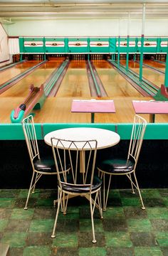 a bowling alley with two tables and chairs