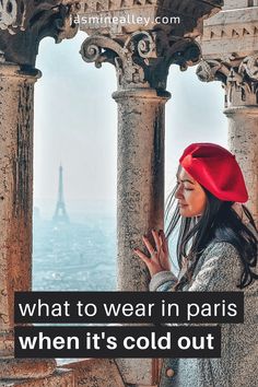 a woman wearing a red hat looking out at the eiffel tower in paris