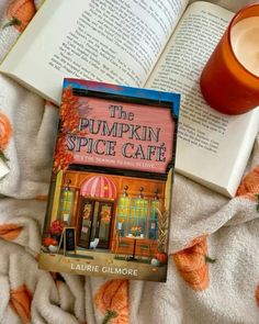 the pumpkin spice cafe by laurie glimone is on a blanket next to an open book